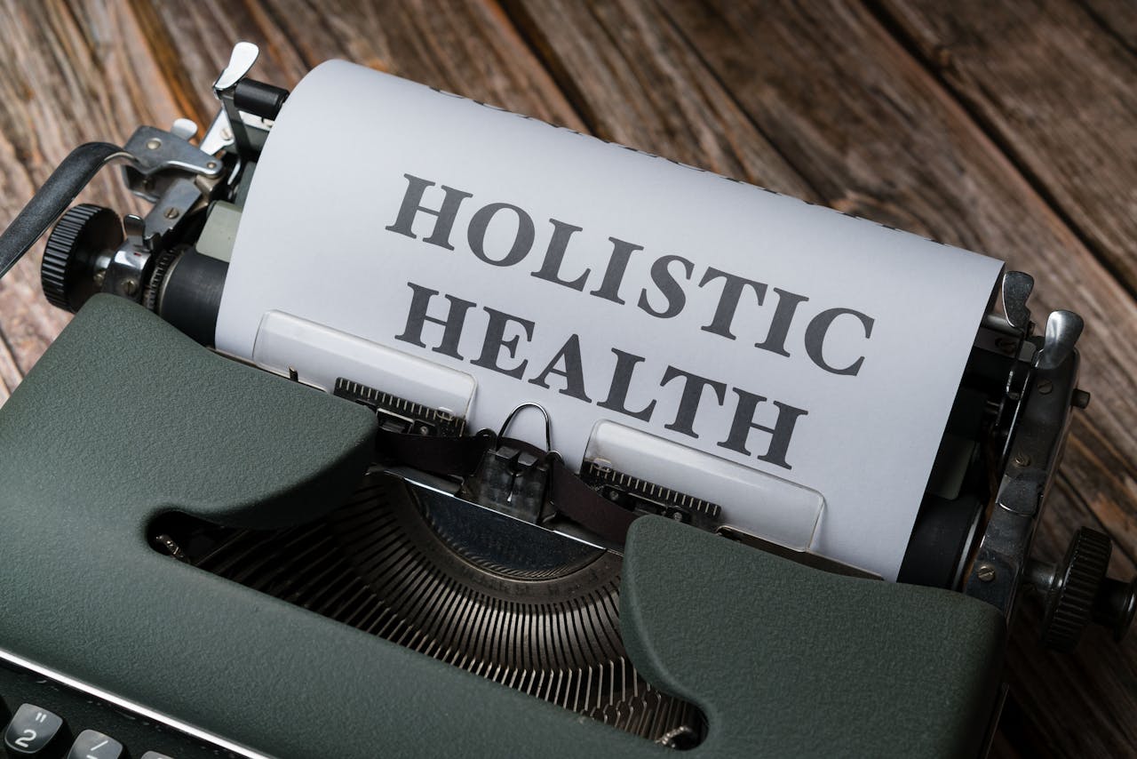 Close-up of a vintage typewriter with 'Holistic Health' on paper, representing wellness.
